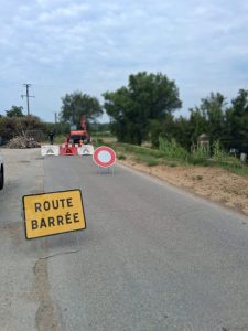 Un panneau route barrée jaune en premier plan, un panneau B0 rond blanc avec liseret rouge, 4 GBA rouge et blanc pour fermer la voie et des lampes de chantier clignotantes pour signaler de nuit